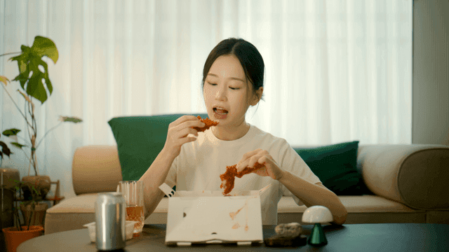 Woman eating seasoned chicken at home