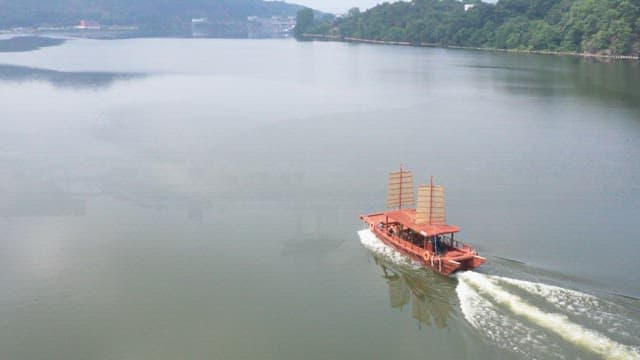 잔잔한 호수 위를 가르는 전통 돛배