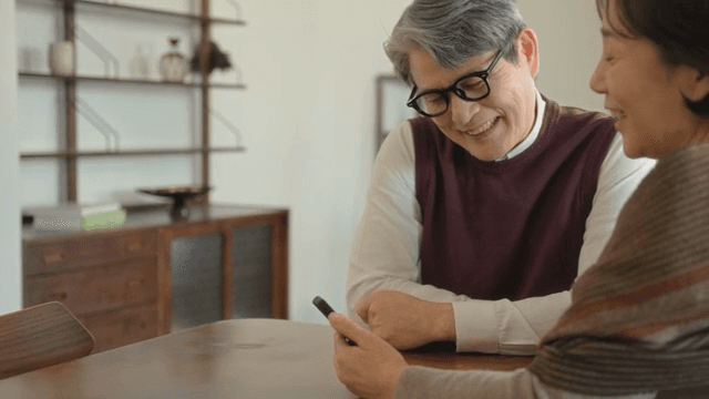 Elderly couple talking while looking at their cell phones