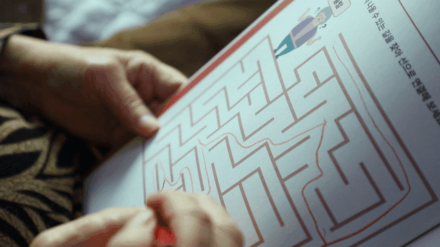 Elderly person solving a maze puzzle