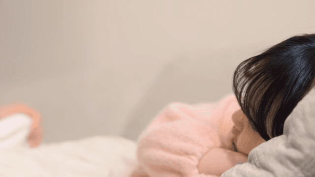 Father covering his sleeping child with a blanket