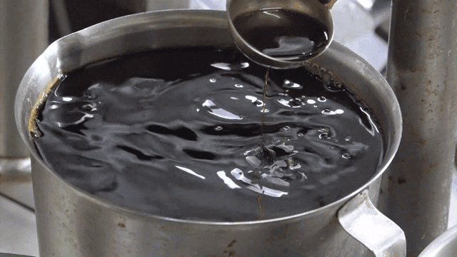 큰 계량컵에 가득 담긴 진한 간장을 퍼내는 국자