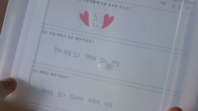 손으로 쓴 설문지를 검토하는 사람