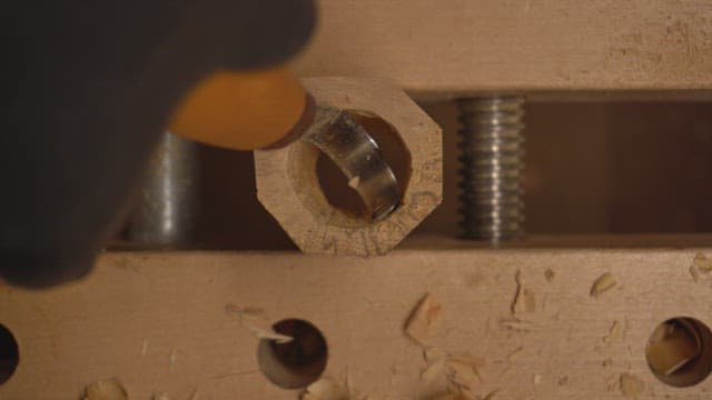 Person carving wood indoors