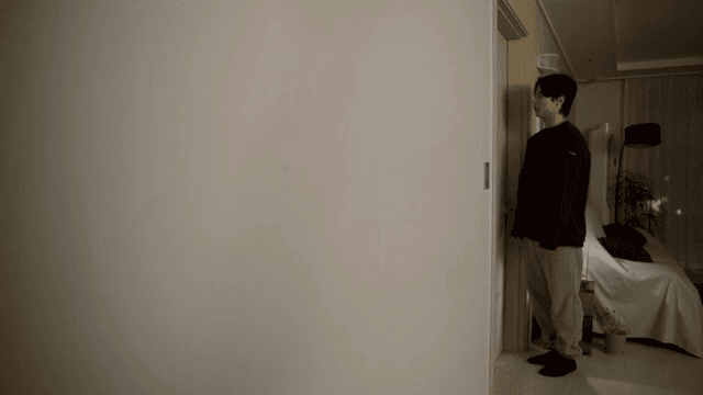 문 옆에 조용히 서 있는 사람