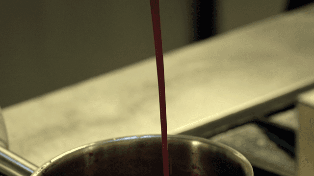 Pouring sauce into a pot on the stove