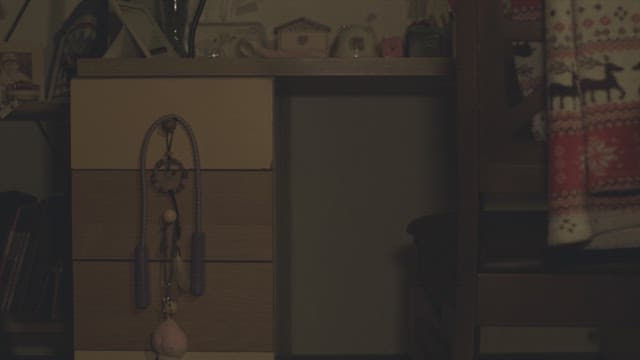 어두운 방안에 들어와 책상에 앉는 학생