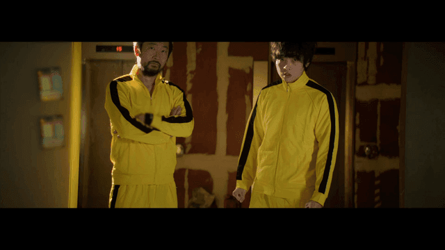 실내에서 노란 트레이닝복을 입은 두 사람