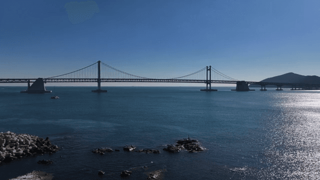 맑은 하늘 아래 고요한 바다 위의 다리