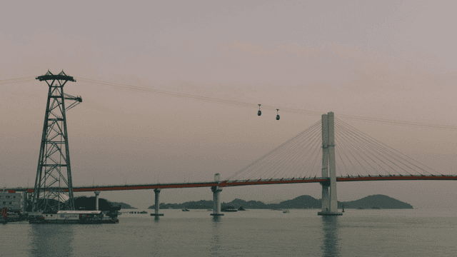 Cable car crossing bridge over sea
