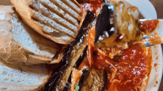 Grilled eggplant gambas scooped out with fork
