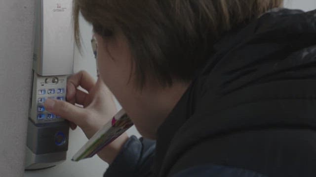 현관문 도어락 키패드를 누르는 여자