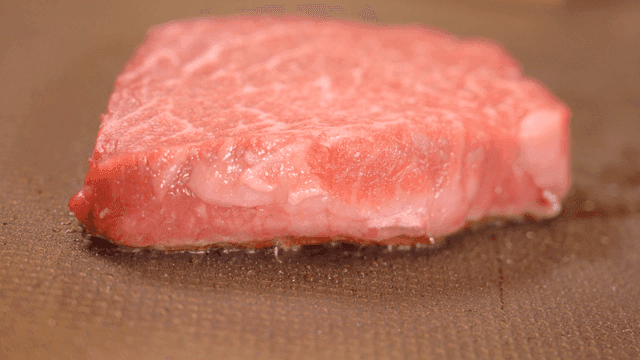 그릴 위에서 구워지고 있는 생 스테이크 조각