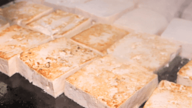 Tofu being grilled on a hot pan