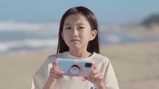 핸드폰을 들고 있던 소녀가 바다로 뛰어가는 모습