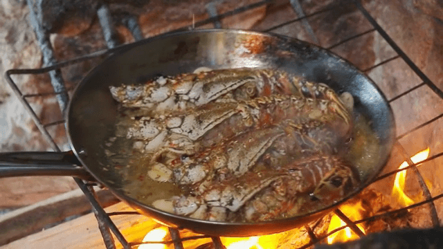 불 위에서 팬에 요리되는 바닷가재