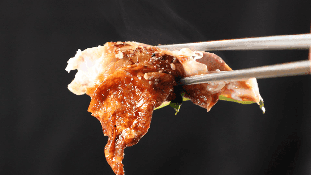 Grilled chicken held with chopsticks
