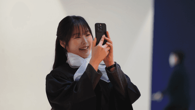 Graduates taking pictures with their cell phones