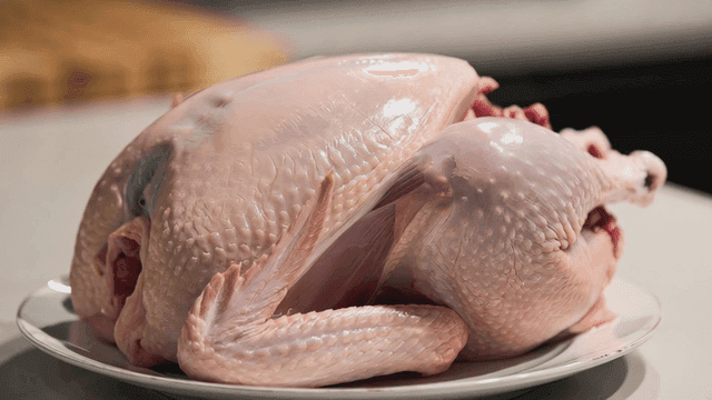 Raw chicken placed on a white plate