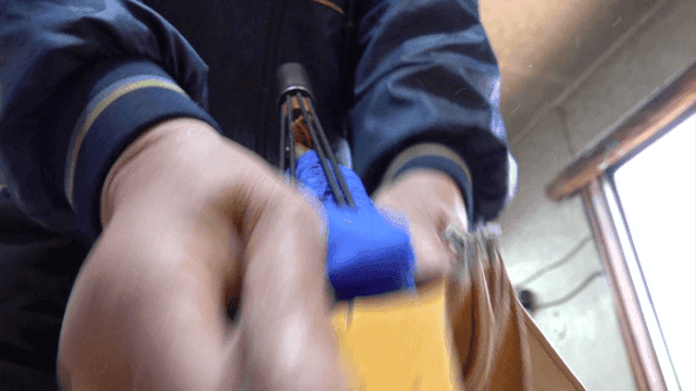 Worker shaping leather gloves in workshop