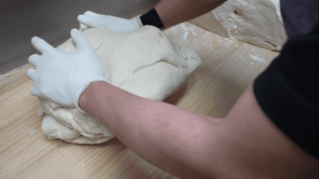 나무 테이블 위에서 반죽을 치대는 손