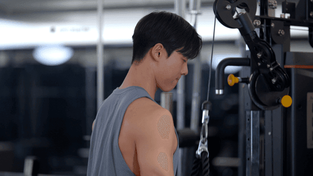 로프를 사용하여 헬스장에서 팔 운동하는 남성