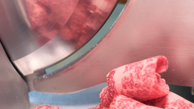 고기 절단기에서 잘려나오는 냉동 소고기