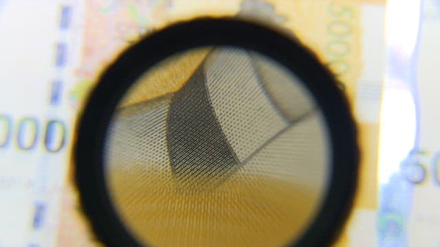 Design elements to prevent counterfeiting through a magnifying glass