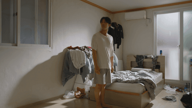 Man standing in a messy bedroom