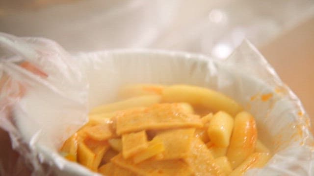 Tteokbokki being served in a bowl