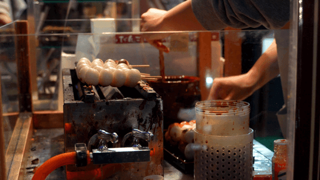 Scene of grilling Japanese dango skewers at street stall