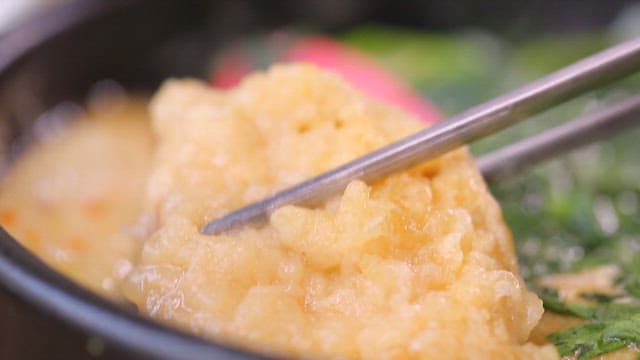 Spoonful of fish cakes lifted from the warm broth