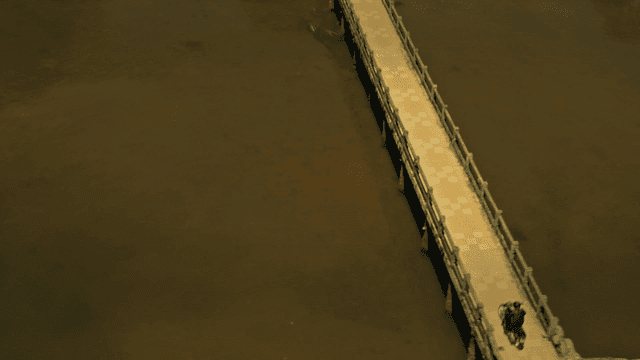 용 조각상이 있는 호수 위 다리를 건너는 오토바이