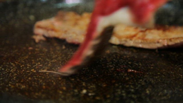 Sizzling beef slices on a hot pan