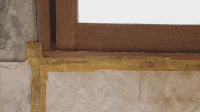 Window with yellow tape on the wall