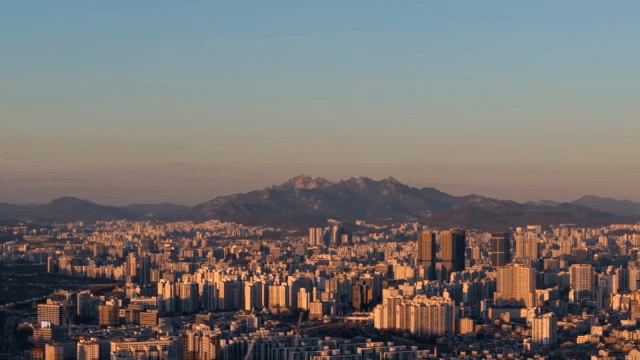 Sunset over a cityscape with distant mountains in view