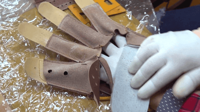 Worker assembling leather glove