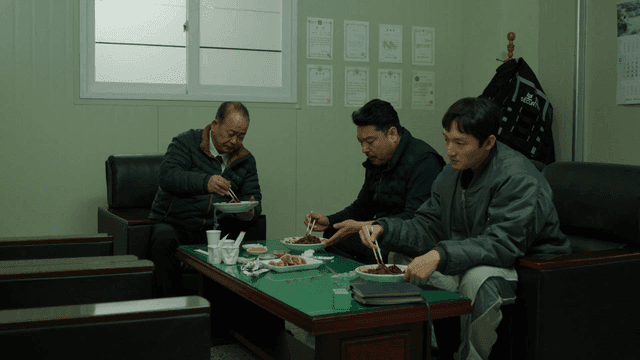 Three men eating jajangmyeon in office