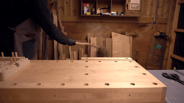 나무 작업대를 청소하는 사람