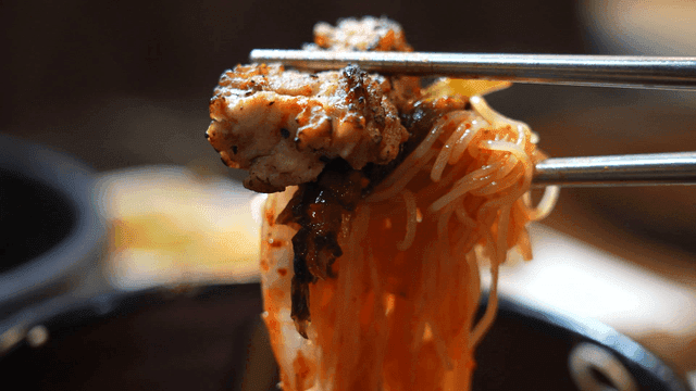 Bibim noodles topped with grilled meat
