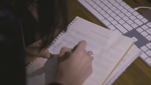 Person who writes music in notebook