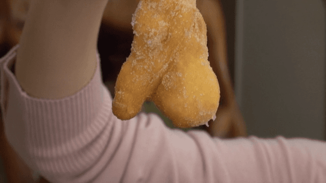 설탕을 입힌 꽈배기를 들고 있는 손