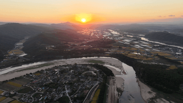 Scenery of rice fields by quiet river at sunset