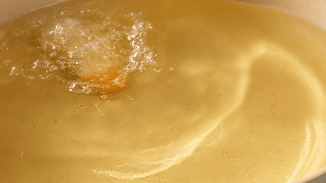 Frying chicken in hot oil in a pan