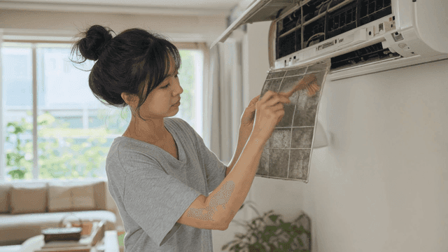 Woman cleaning air conditioner filter
