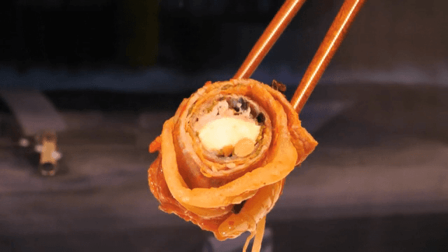 젓가락으로 김치 롤을 집는 모습