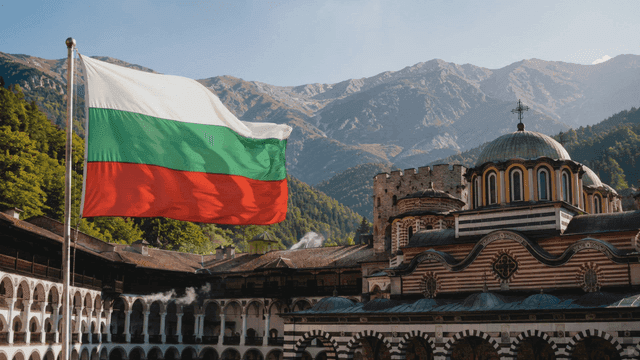 Historic monastery with mountain backdrop and Bulgarian flag