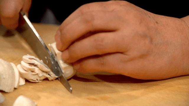 나무 도마 위에서 버섯을 자르는 모습