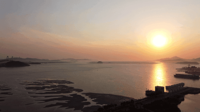 Distant mountains, sunset over calm sea