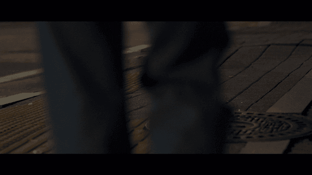 Person's legs staggering on quiet street at night